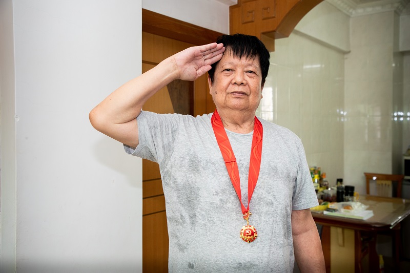 老党员孙秀煌接过纪念章后激动地敬礼.jpg